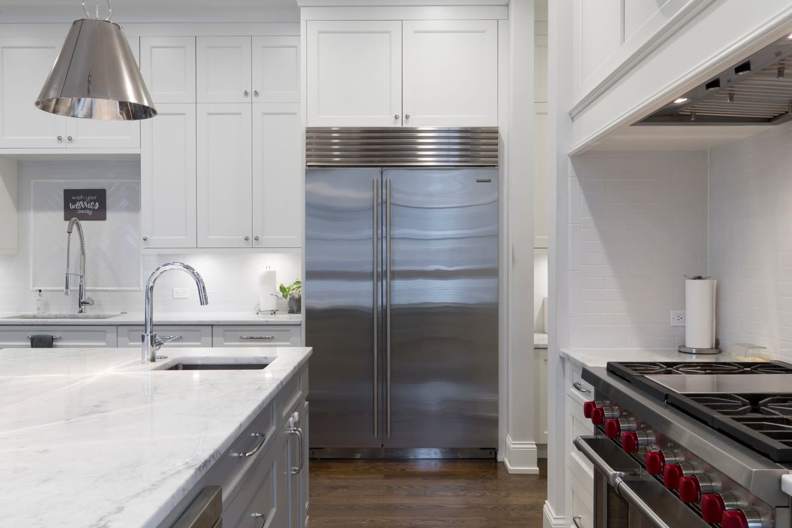 Large stainless refrigerator set flush between kitchen cabinets
