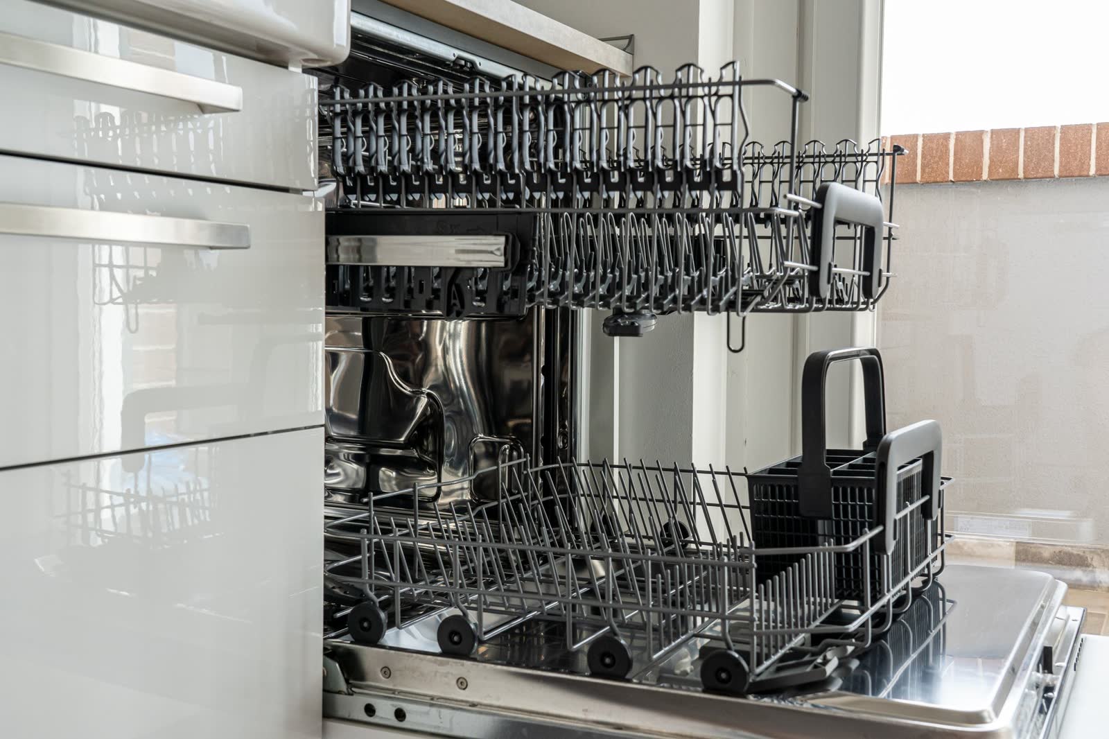 Built-in dishwasher with the door open and racks pulled out