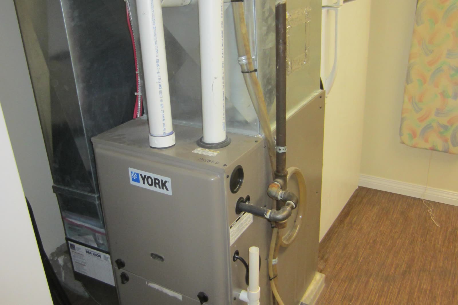 Condensing gas furnace with PVC vent pipes and metal ductwork in a utility room