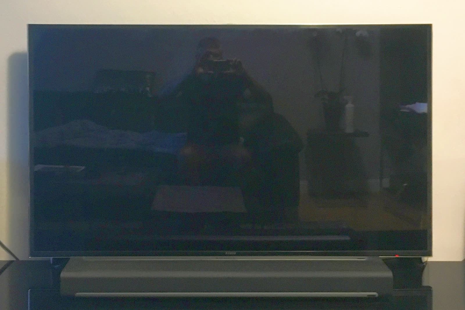 Soundbar sitting under a flat-screen TV