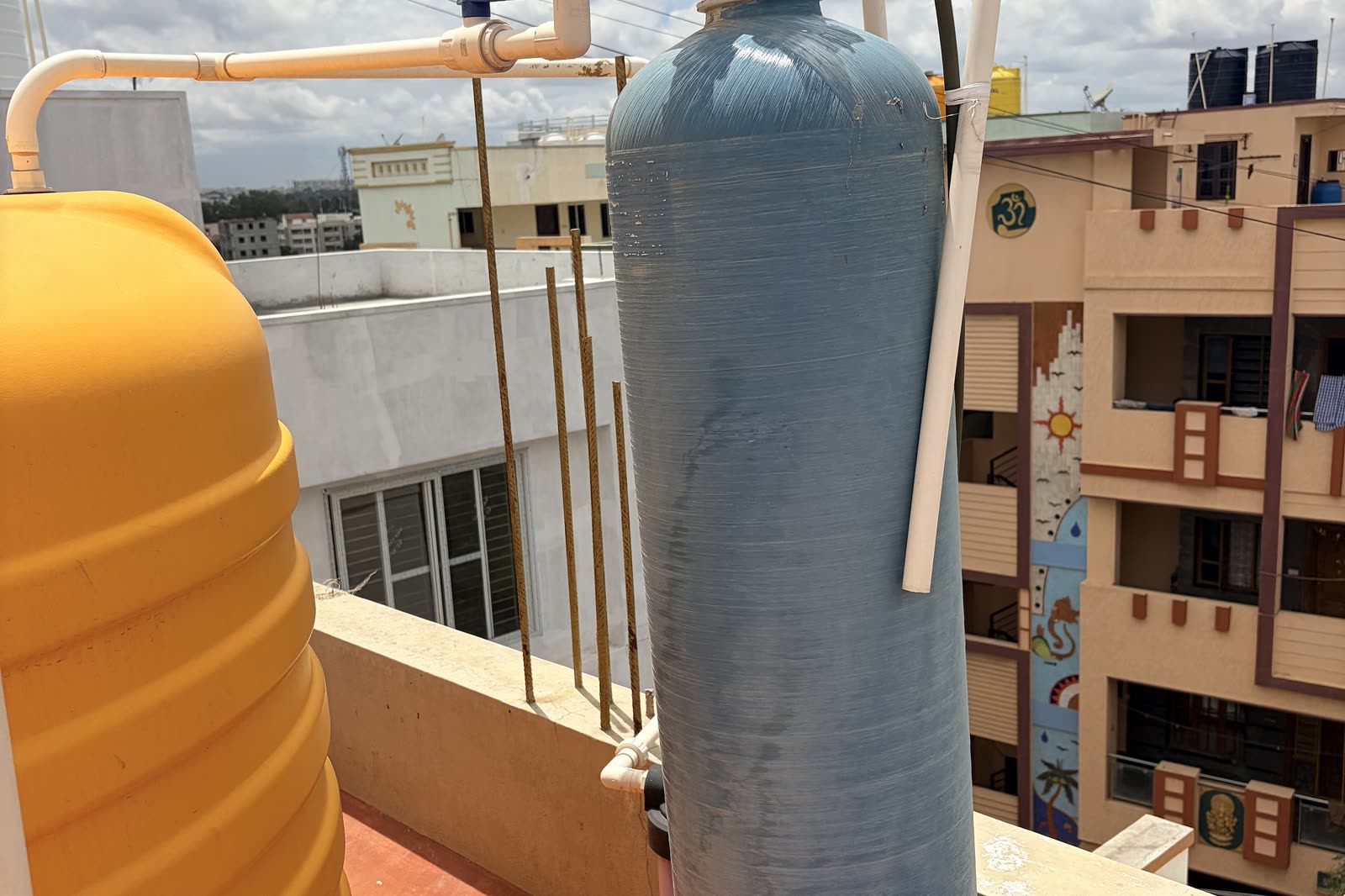 Water softener resin tank with its control valve next to a storage tank