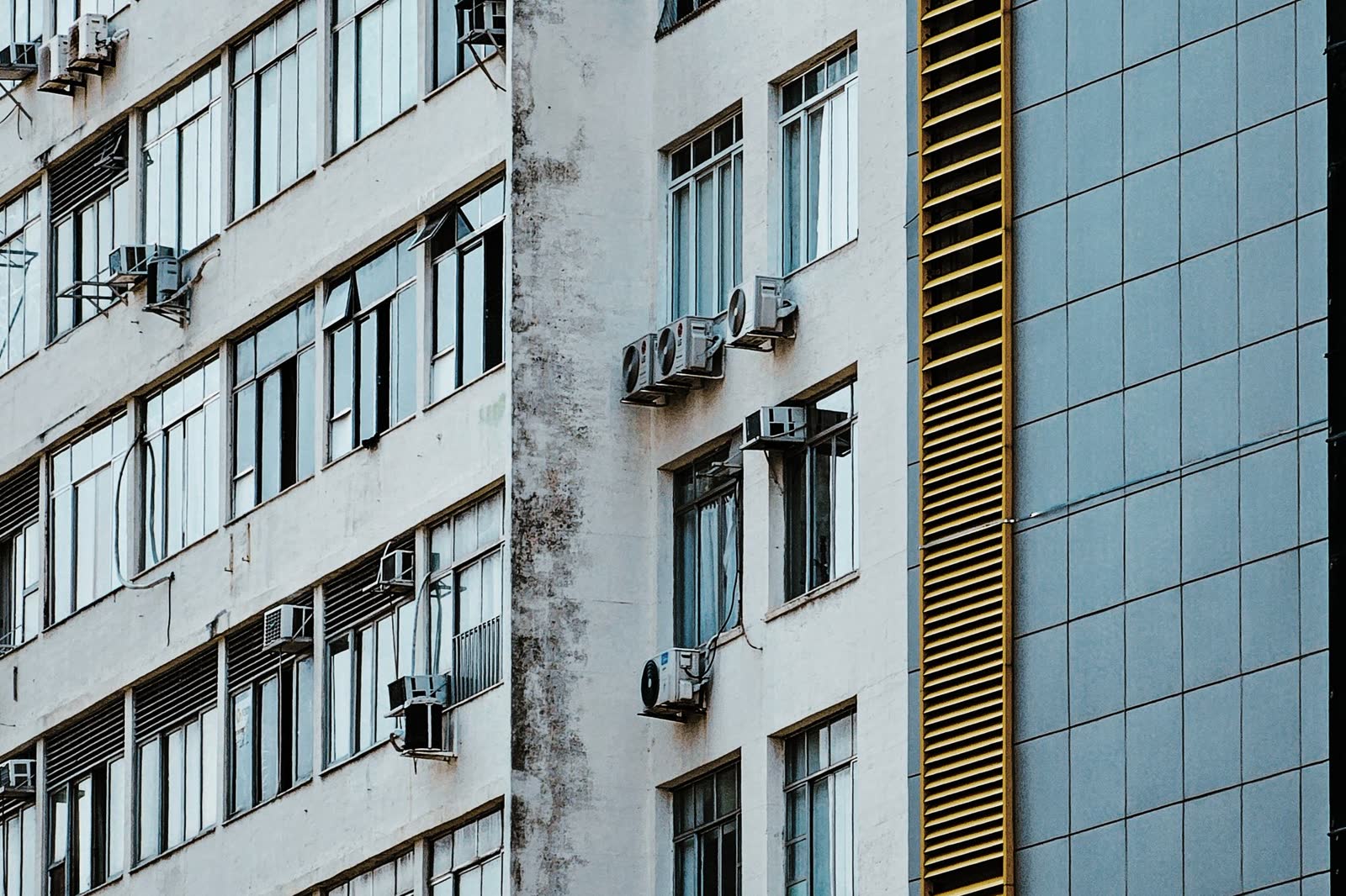 Building facade with window and wall air conditioner units