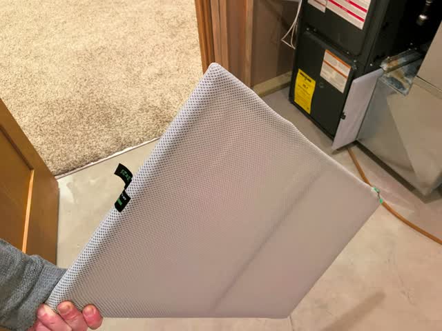 16x25 inch HVAC return air filter being removed beside a furnace