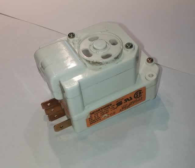 Refrigerator defrost timer with spade terminals and the manual advance slot on the front