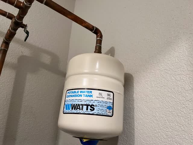 Thermal expansion tank installed on the water lines above a water heater