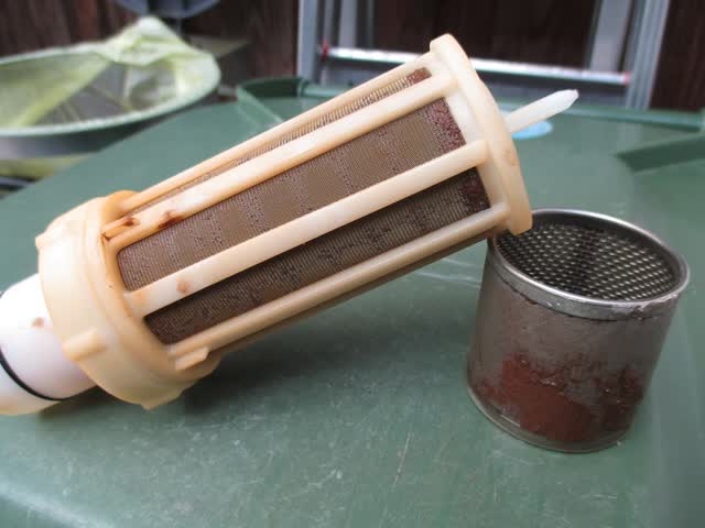 Whole-house water filter cartridge and screen clogged with rust sediment