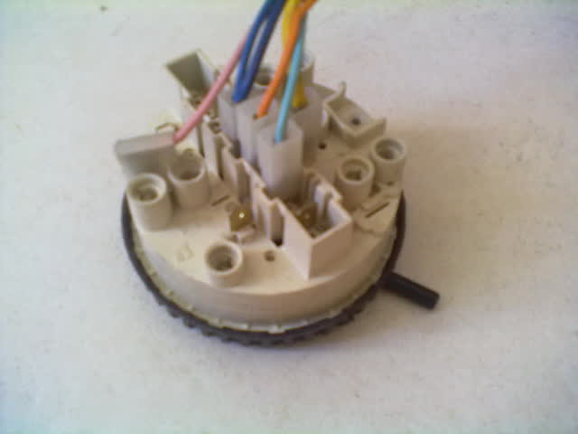 Washer water-level pressure switch removed, with its wiring connectors on top and the small air-hose nipple on the side where the pressure tube attaches
